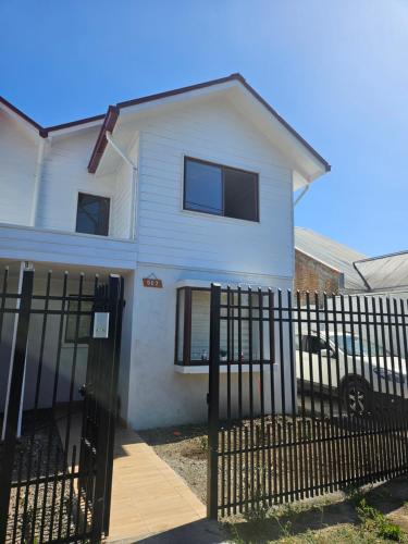 a white house with a fence in front of it at Casa con estacionamiento privado in San Carlos