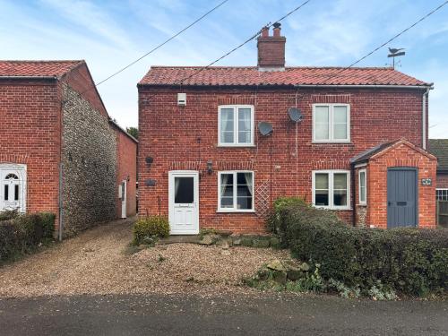 een rood bakstenen huis met een witte deur bij Jasmine Cottage - Uk50585 in Bintree