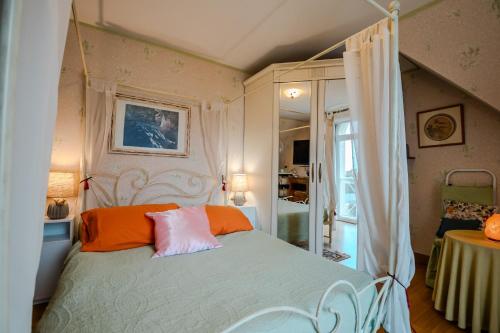 Un dormitorio con una cama con almohadas naranjas y blancas. en Courseulles Comme À La Maison, en Courseulles-sur-Mer