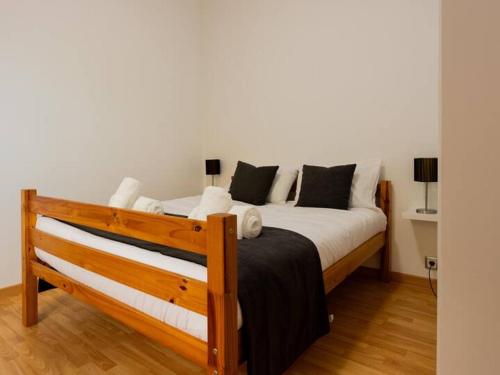 a bedroom with a wooden bed with white sheets at Skyline Villas RC in Arco da Calheta