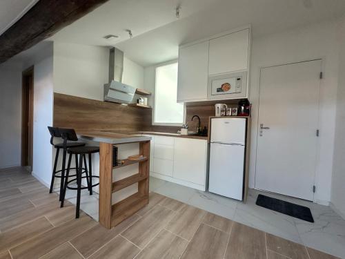 een keuken met witte kasten en een witte koelkast bij Le Graoully 1 in Metz