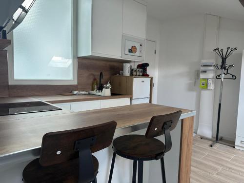 een keuken met twee stoelen aan een houten aanrecht bij Le Graoully 1 in Metz