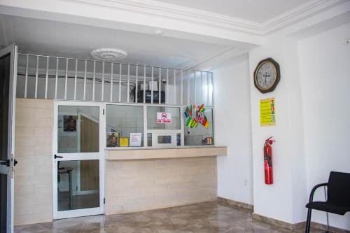 una habitación con un estante y un reloj en la pared en Hotel Mboloani, en Lomé