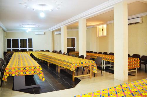 una sala de conferencias con mesas y sillas con mantel amarillo en Hotel Mboloani, en Lomé
