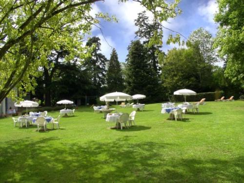 a group of tables and chairs with umbrellas on a field at La Renaudière in Chenonceaux