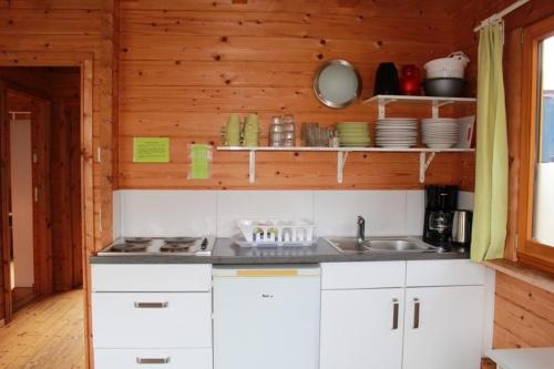 a kitchen with white cabinets and a sink at NabeDi-Blockhaus in Simmerath