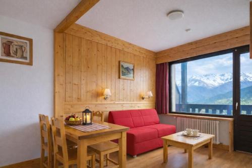 uma sala de estar com um sofá vermelho e uma mesa em Résidence & Spa La Grande Cordée - Combloux em Combloux