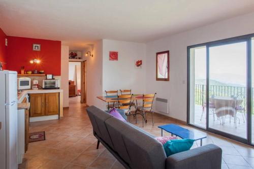 ein Wohnzimmer mit Couch und Tisch und eine Küche in der Unterkunft Gîtes la fontaine corse vue panoramique in Loreto-di-Casinca