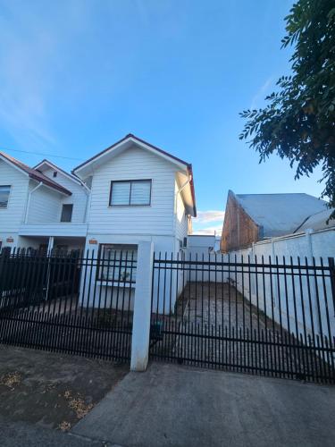 a white house with a fence in front of it at Casa con estacionamiento privado in San Carlos