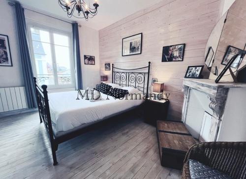 een slaapkamer met een groot bed en een open haard bij Belle Maison centre Villerville - 8 personnes - Terrasse in Villerville