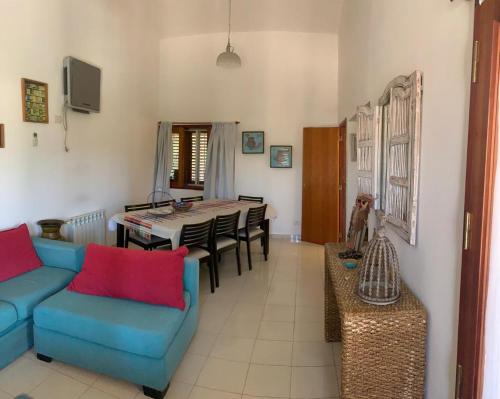 een woonkamer met een blauwe bank en een tafel bij Casa Maru in Villa Carlos Paz