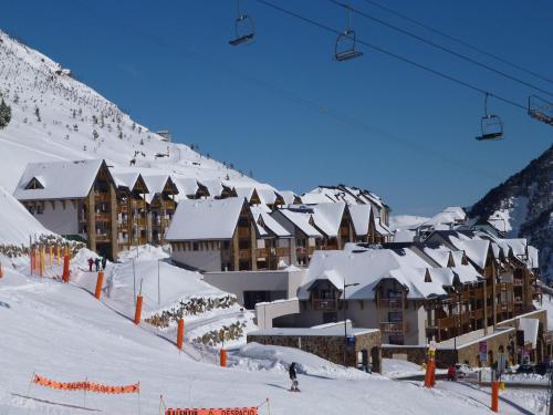 a ski resort with snow covered buildings and a ski lift at Résidence Mer & Golf Tourmalet in La Mongie