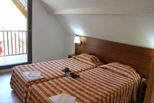 ein Hotelzimmer mit einem Bett mit Kamera drauf in der Unterkunft Résidence Mer & Golf Tourmalet in La Mongie