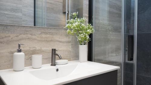 a bathroom sink with a vase of flowers on it at Be Mate Citylife in Milan