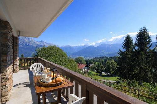 uma mesa numa varanda com vista para as montanhas em Résidence & Spa La Grande Cordée - Combloux em Combloux