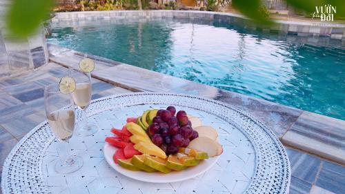 Trại VangVườn Trên Đồi Retreat Villa的池边桌子上的一盘水果