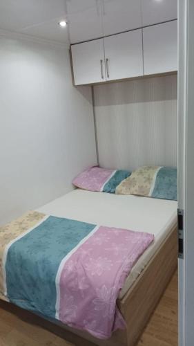 two beds in a small room with white cabinets at Mobil home Katka in Biograd na Moru