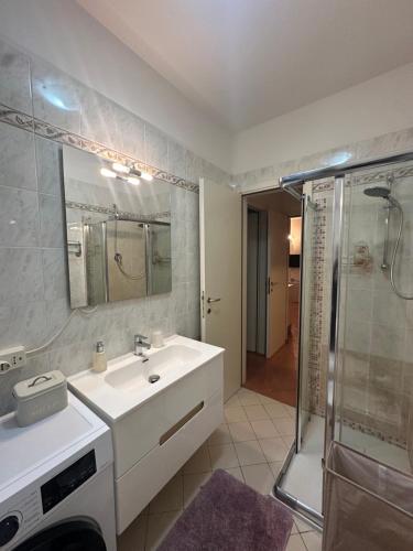 a bathroom with a sink and a shower at Delphina House in Lido delle Nazioni