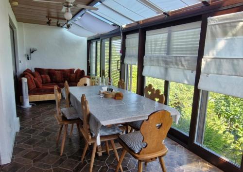 een eetkamer met een tafel, stoelen en een bank bij Ferienhaus Rhönblick in Bischofsheim an der Rhön