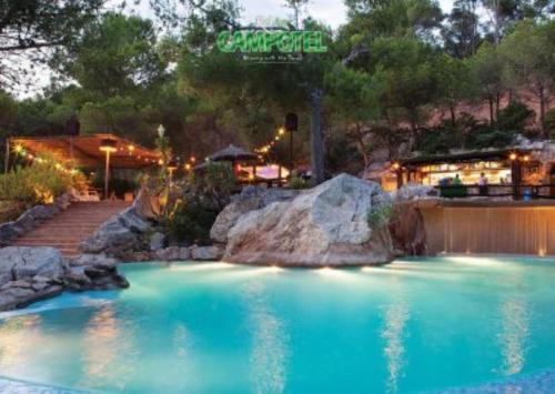 Una piscina de agua azul con rocas en un patio. en Mobile Homes by KelAir at Castell Montgri, en Torroella de Montgrí