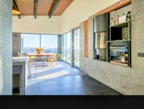 Blackhouse jacuzzi piscina في بونتيفيدرا: مطبخ وغرفة طعام مع طاولة مع كراسي