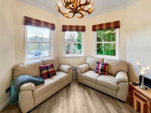 a living room with two couches and two windows at Dee View Apartment in Banchory