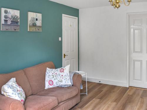a living room with a brown couch and blue walls at Little Fishes in Ryde