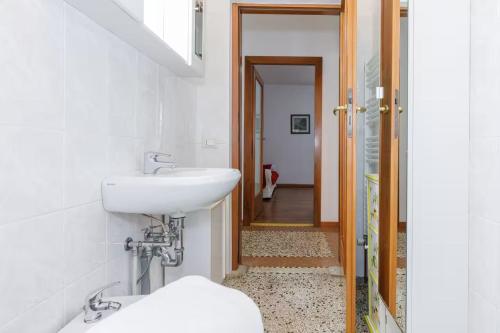 a white bathroom with a sink and a mirror at Apartment with Free Parking Easy Access to Venice in Mestre