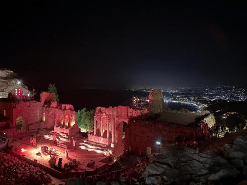 um grande edifício com luzes acesas à noite em Paradise By The Sea em Taormina