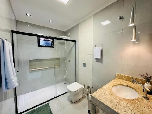 ein Badezimmer mit Dusche, Toilette und Waschbecken in der Unterkunft Casa c/ Suíte, Ar Cond, Área Gourmet, Bairro Nobre in Ourinhos
