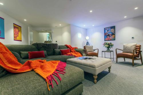 a living room with a green couch with an orange blanket at St James Central Splendor in Bath