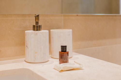 a bottle of soap sitting on top of a bathroom sink at Modern apt with 2 BR BBQ and views in Pendales