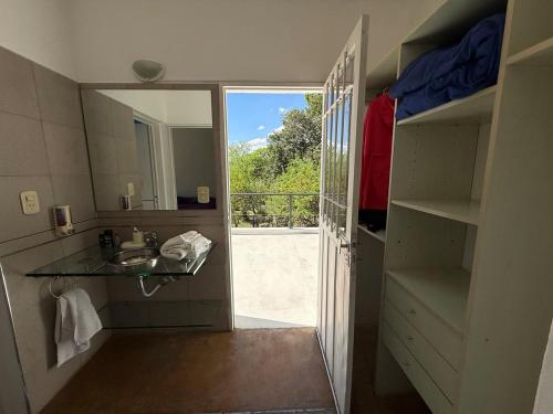 a bathroom with a sink and a door to a balcony at Poseidon in Las Chacras (La Paz)