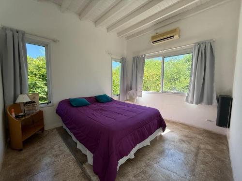 a bedroom with a purple bed in a room with windows at Poseidon in Las Chacras (La Paz)