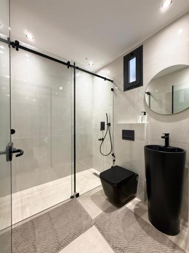 a bathroom with a shower and a black toilet at Villa 2 Évasion Urbaine, 3 Chambres, à 20 min de Rabat in Sidi Yahia az Zaʼer