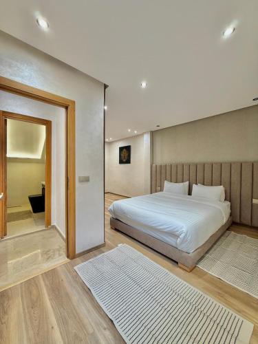 a bedroom with a large bed and a mirror at Villa 2 Évasion Urbaine, 3 Chambres, à 20 min de Rabat in Sidi Yahia az Zaʼer