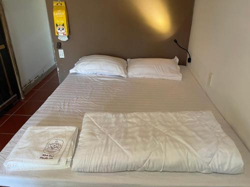 zwei Betten in einem Zimmer mit weißen Laken und Kissen in der Unterkunft Nhà Sen Phước Hải in Hội Mỹ
