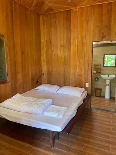 een bed in een kamer met een houten wand bij Nhà Sen Phước Hải in Hội Mỹ