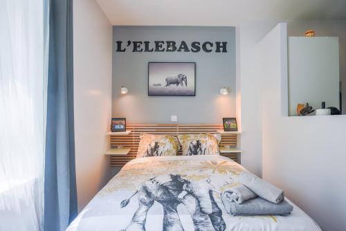 ein Schlafzimmer mit einem Bett und einem Schild an der Wand in der Unterkunft L'ELEBASCH - Riom - Randonnée Puy de Dôme in Riom