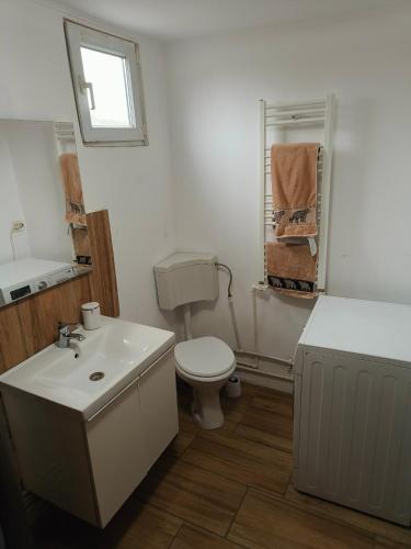 a white bathroom with a toilet and a sink at Casa Razu G2 in Craiova