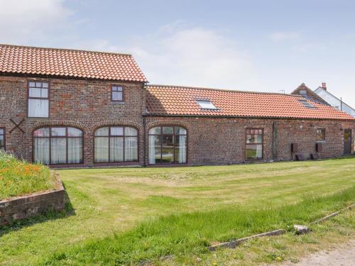 a brick building with a grass yard in front of it at Robin in Flamborough