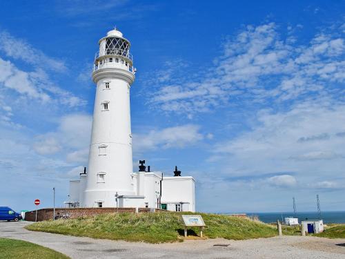 a white lighthouse sitting on top of a hill at Robin in Flamborough