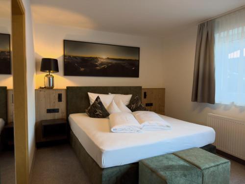 a bedroom with a bed with white sheets and pillows at Haus Sonneneck - ski in & out in Sankt Anton am Arlberg