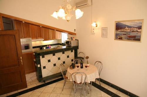 a kitchen with a table and chairs in a room at Bonacic Palace in Slatine