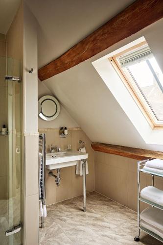 a bathroom with a sink and a skylight at Fawsley Hall Hotel in Daventry