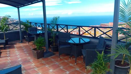een balkon met tafels en stoelen en de oceaan bij Apartamentos Monasterio de San Antonio - adults only in Icod de los Vinos