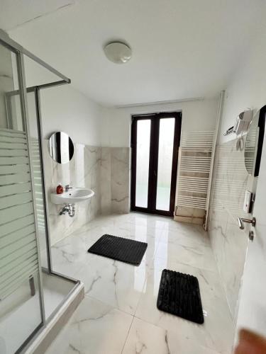 un bagno bianco con doccia e lavandino di Gröpelinger Guesthouse a Brema