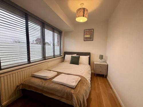 een slaapkamer met een bed en een raam bij Spacious 4-Bed Home in Ascot in Ascot