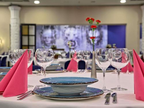 a table with red napkins and wine glasses on it at Mercure Gdańsk Stare Miasto in Gdańsk