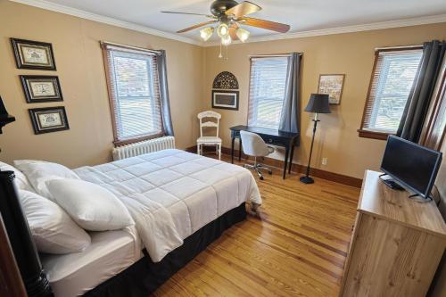Schlafzimmer mit einem Bett, einem Deckenventilator und einem Schreibtisch in der Unterkunft Suites On Chocolate - The Hershey House in Hershey